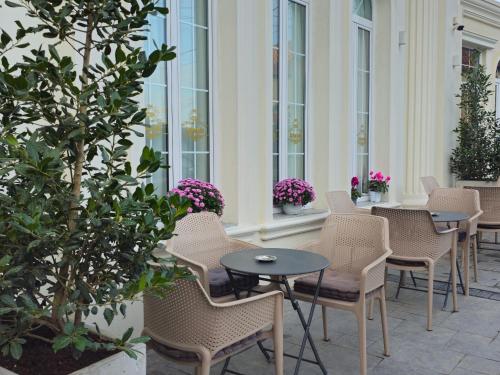 a row of chairs and tables in a courtyard at Hotel Ambasada QTA in Patza-Kuqani