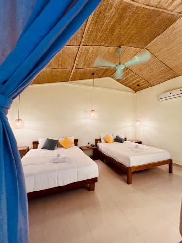 two beds in a room with blue curtains at New Yêu Biển homestay in Vĩnh Hy