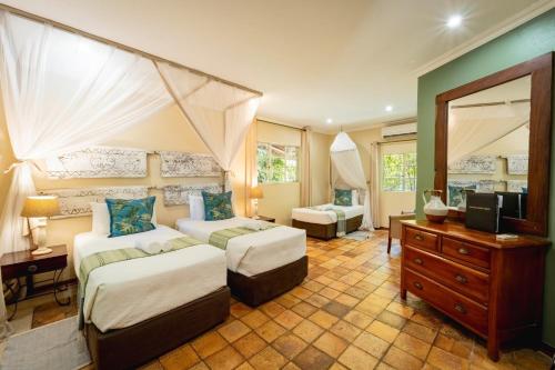a bedroom with two beds and a television in it at Bayete Guest Lodge in Victoria Falls