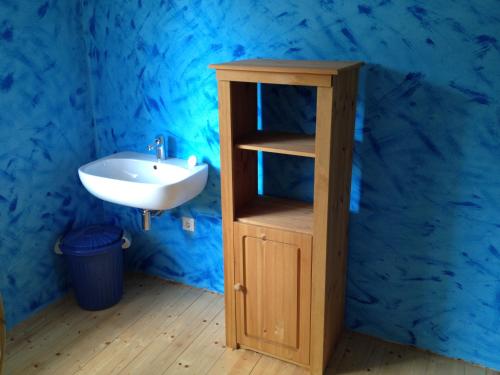 uma casa de banho com um lavatório e um armário de madeira em Idyllisches Ferienhaus im Fichtelgebirge em Nagel