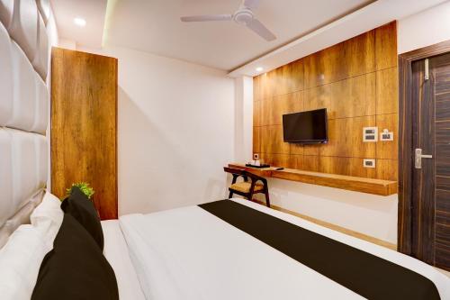 a bedroom with a bed and a tv on a wall at Hotel O Haridwar Near Shanti Kunj in Haridwār