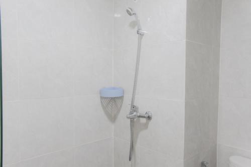 a shower with a shower head in a bathroom at Comfort Minimalist Studio at Parkland Avenue Apartment By Travelio in Tangerang