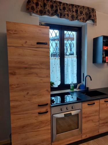 a kitchen with a stove and a window at APPARTAMENTO CHEMIN DE FER in Saint Vincent