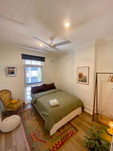 a bedroom with a bed and a chair and a window at Casa Portuguesa in Sydney