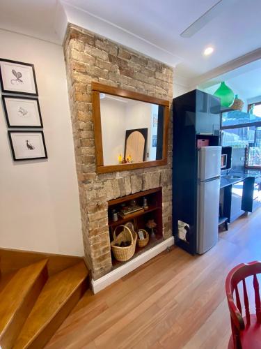 a stone fireplace in a living room with a mirror at Casa Portuguesa in Sydney