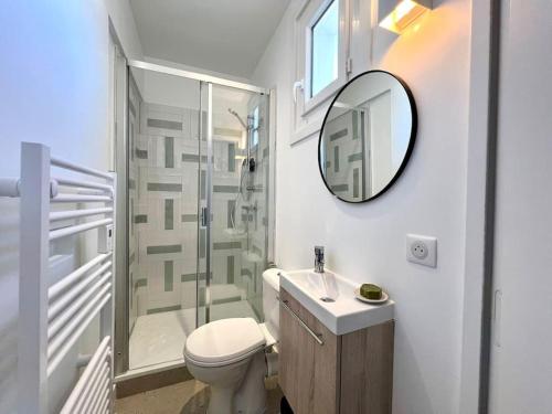 une salle de bain avec toilettes, lavabo et miroir dans l'établissement Studio lumineux à 100m de la plage !, à Saint-Jean-de-Luz