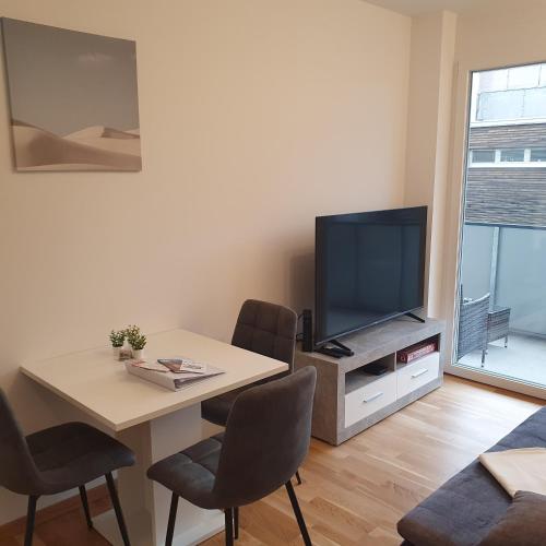 a living room with a table and a television at Primelweg Apartments in Graz