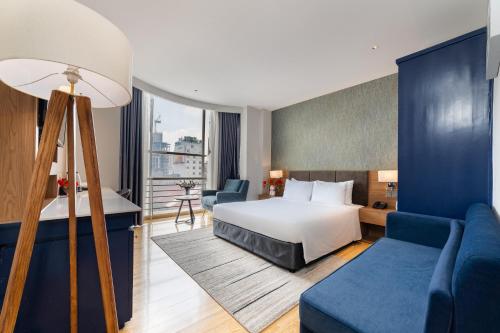a hotel room with a bed and a couch at Nicecy NganHa Hotel in Ho Chi Minh City