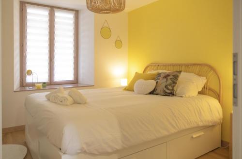 a bedroom with a bed with white sheets and a window at Au Fil de l'Eau - Cosy in Barr