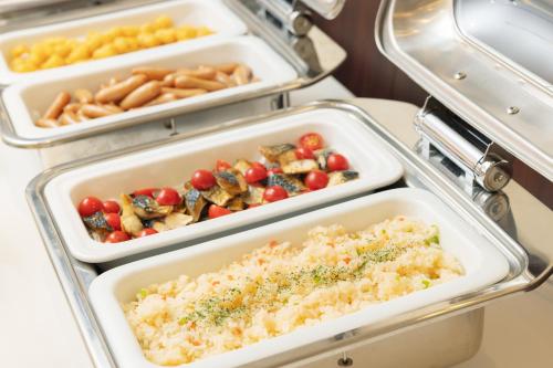 an open refrigerator with trays of different types of food at Hotel Centmain Nagoya in Nagoya