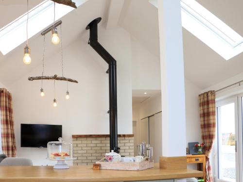 a fireplace in a living room with white walls at Bayview Byre in Knock