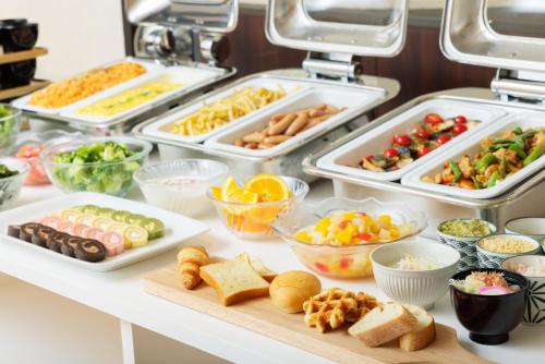 a buffet with different types of food in trays at Hotel Centmain Nagoya in Nagoya
