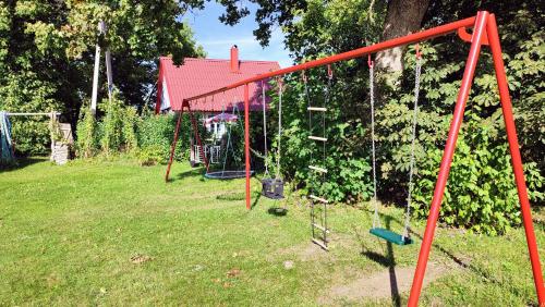 a swing set in a yard with a garden at Viini puhkemaja in Myustelʼ