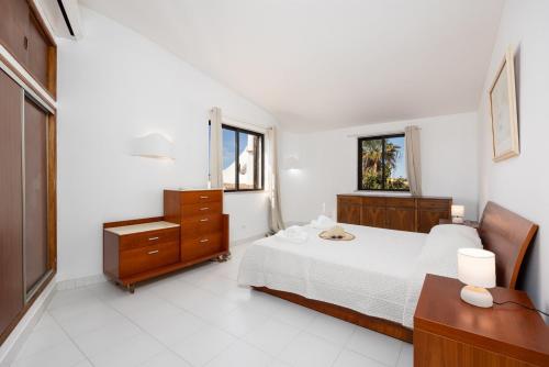 a bedroom with a bed and a dresser and window at Villa Veiguinha in Galé