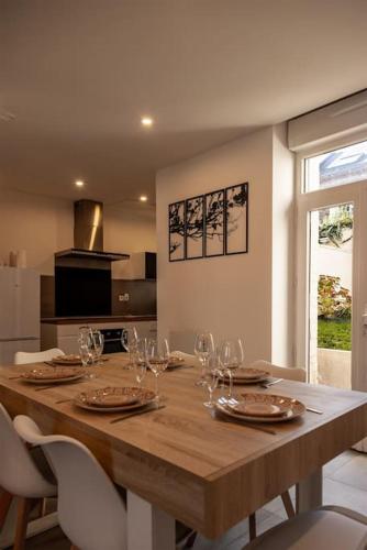 - une table en bois avec des verres à vin dans la cuisine dans l'établissement Une Parenthèse Carolo, à Charleville-Mézières