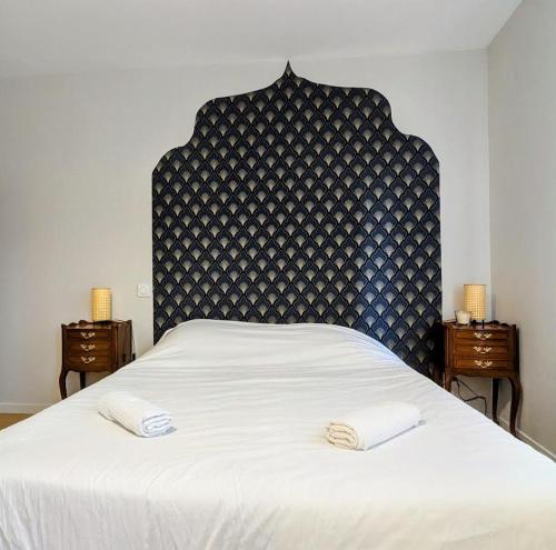 a bed with two white towels on top of it at Le Riad, sauna & jacuzzi in Riorges