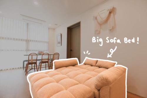 a couch in a living room with a big sofa bed at Hongik Univ Station Wave Family Suite #1 in Seoul
