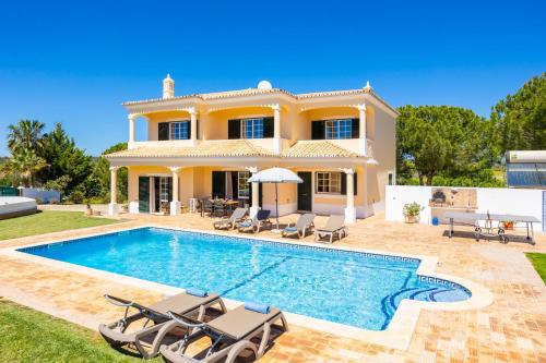 a villa with a swimming pool in front of a house at Quinta Monte dos Avos in Guia