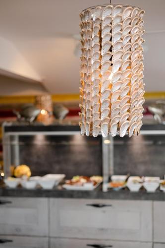 a chandelier in a kitchen with plates of food at Apartmenthotel am Leuchtturm in Hörnum