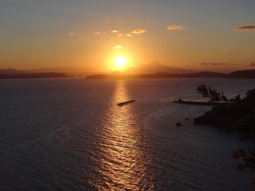 a sunset over a large body of water at Hotel Myage in Ischia
