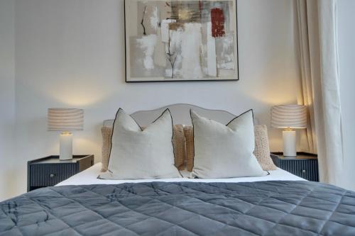 a bedroom with a bed with pillows and two lamps at Clover lodge Portsmouth luxury home with off road free parking in Portsmouth