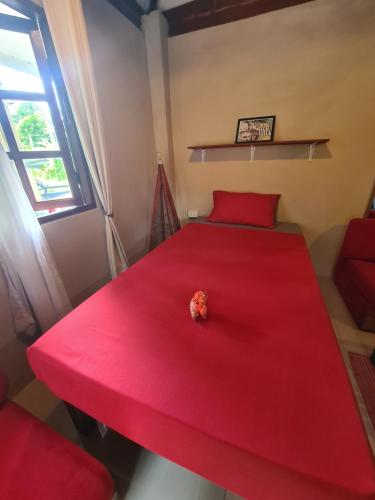 a red bed with a piece of food on it at Red Moon Hideaway in Ko Chang
