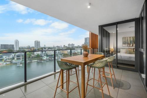 a room with a balcony with a table and chairs at The Haven - Brand New Riverview 2BR with Parking Pool GYM at Surfers Paradise in Gold Coast