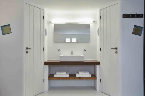 a bathroom with a sink and a mirror at Almyra Guest Houses in Paraga