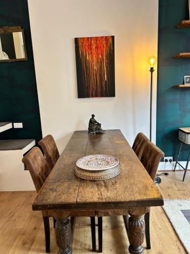 a wooden table with chairs in a room with a painting at Casa Rosa, Notting Hill in London