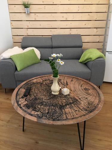 a coffee table with a vase on it in front of a couch at Deluxe Apartment Sonnleitner - ADULTS ONLY in Furth
