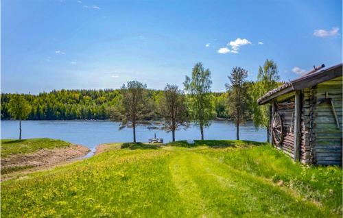une maison sur une pelouse à côté d'un lac dans l'établissement 2 Bedroom Amazing Home In Vindeln, à Vindeln