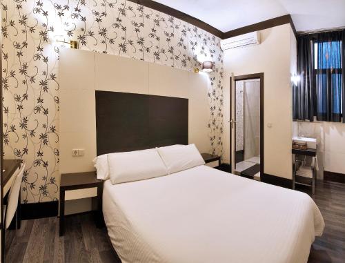 a bedroom with a large white bed in a room at Alhambra Suites in Madrid
