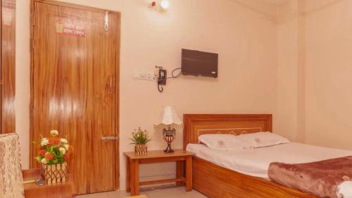 a bedroom with a bed and a tv on the wall at Hotel Sikder Residential Mirpur in Bisil