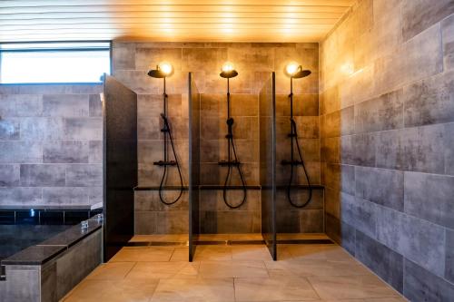 a bathroom with four shower stalls in a wall at Sunrise Villa Oarai in Natsumi