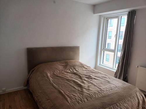 a bed in a white room with a window at Fully equipped apartment, 15 min to Center in Copenhagen
