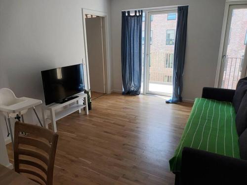 a living room with a couch and a flat screen tv at Fully equipped apartment, 15 min to Center in Copenhagen