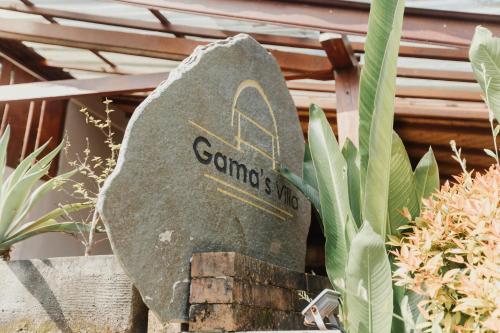 a stone sign for a garden with plants at Gama’s Villa in Tabanan