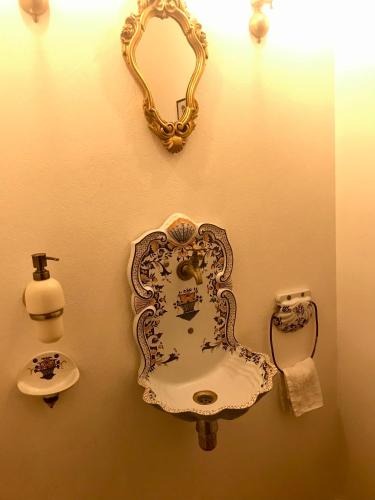 une salle de bain avec un lavabo et un miroir au mur dans l'établissement La maison du lac, à Auvers-sur-Oise