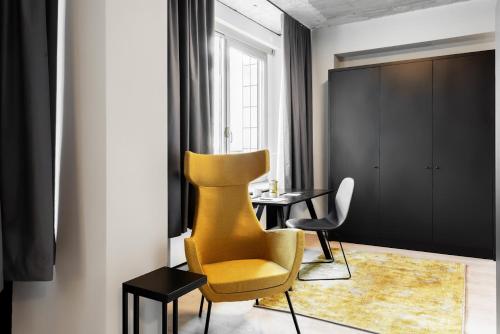 a living room with a yellow chair and a table at Numa Cologne Ehrenfeld in Cologne