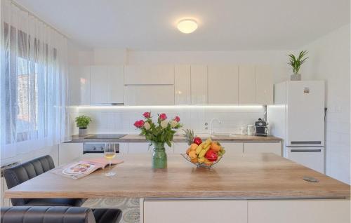 a kitchen with a table with a bowl of fruit at Villa Mendula in Potpićan
