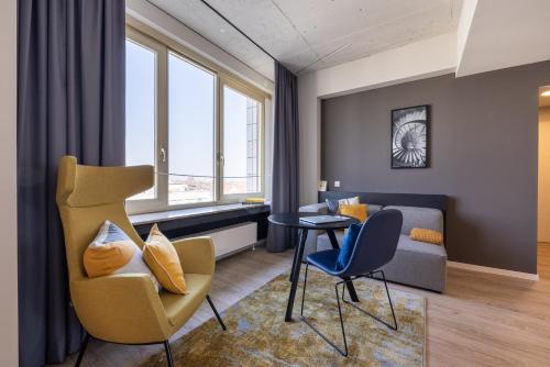 a living room with a couch and a table and chairs at Numa Cologne Ehrenfeld in Cologne