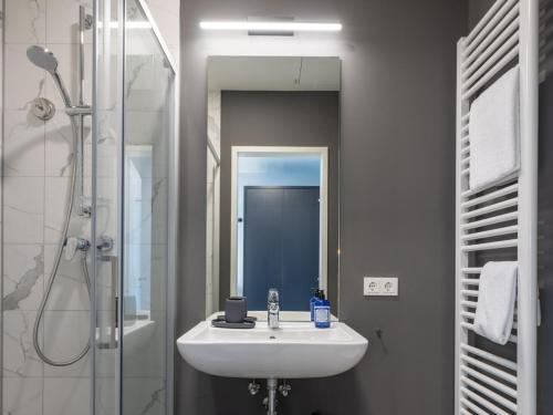 a bathroom with a sink and a shower at Numa Cologne Ehrenfeld in Cologne