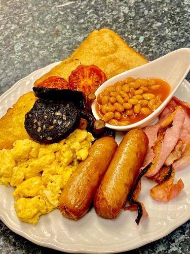 a plate of breakfast food with eggs sausage beans and bacon at Walkden House in Blackpool