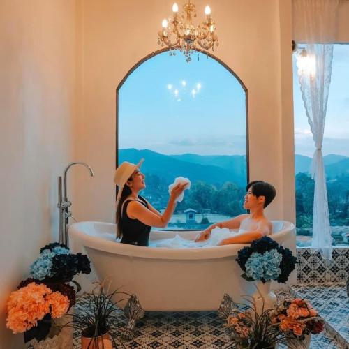 two people sitting in a bath tub in a bathroom at Ping fai camp inthanon in Ban Na Yang