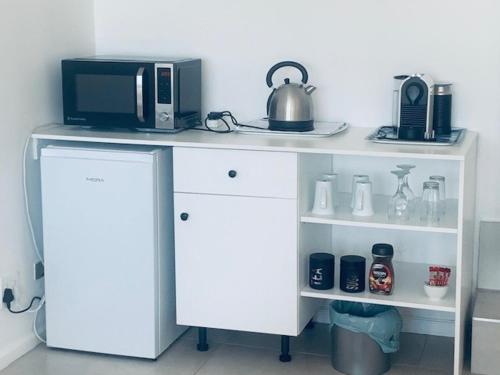 escritorio blanco con microondas y hervidor de agua. en Hawaan View, en Durban