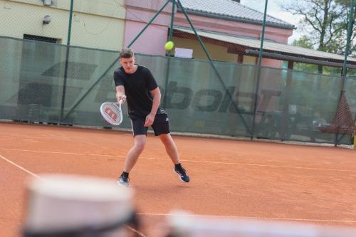 a man holding a tennis racket on a tennis court at Apartmán na Sportovním areálu in Krásná Lípa