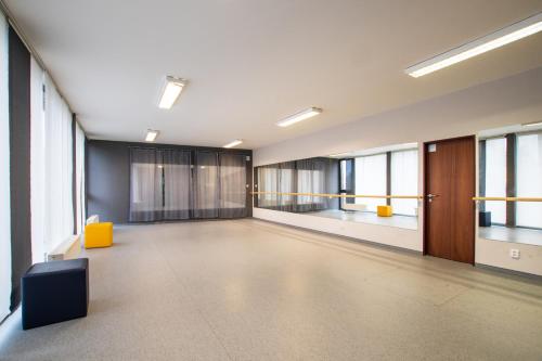 a large empty room with windows and a yellow chair at Apartmán na Sportovním areálu in Krásná Lípa