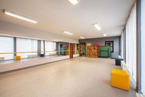 a large empty room with a yellow chair and windows at Apartmán na Sportovním areálu in Krásná Lípa