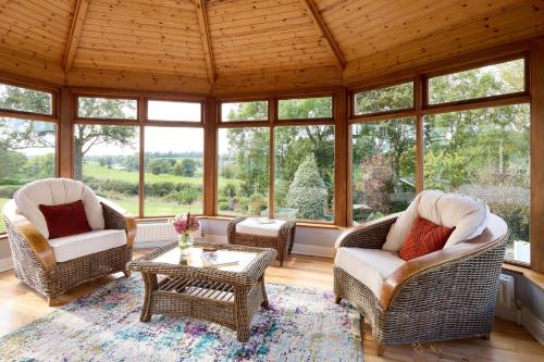 a screened in porch with wicker chairs and a coffee table at Fox House Sleeps 8 w Parking 5 min to Kilmessan in Navan