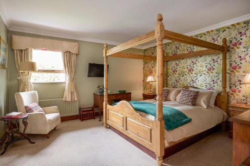 a bedroom with a canopy bed and a chair at Fox House Sleeps 8 w Parking 5 min to Kilmessan in Navan